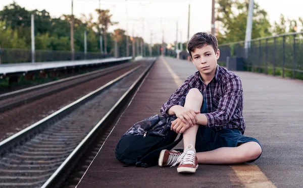 Tiener wachten op een trein op het station — Stockfoto