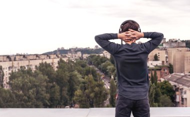 Genç üzerinde kulaklık Evin çatısı