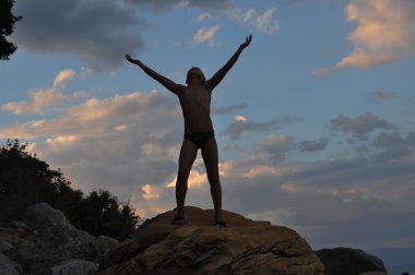 genç adam siluet batımında denize yakın