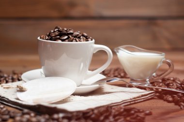 Beyaz fincan kahve ve süt ahşap yüzey üzerinde