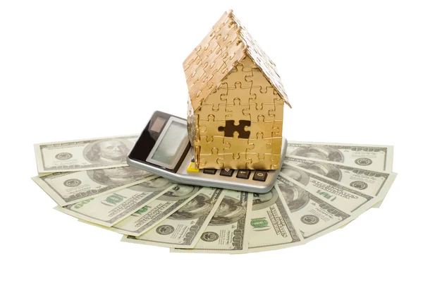 Huis van goud kleur op een rekenmachine en dollars — Stockfoto