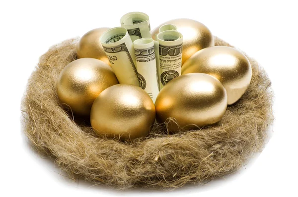 Hnízdo s zlatá vejce na bílém pozadí — Stock fotografie