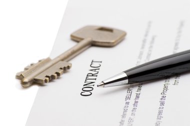 Keys of a new house and pen on contract. clipart