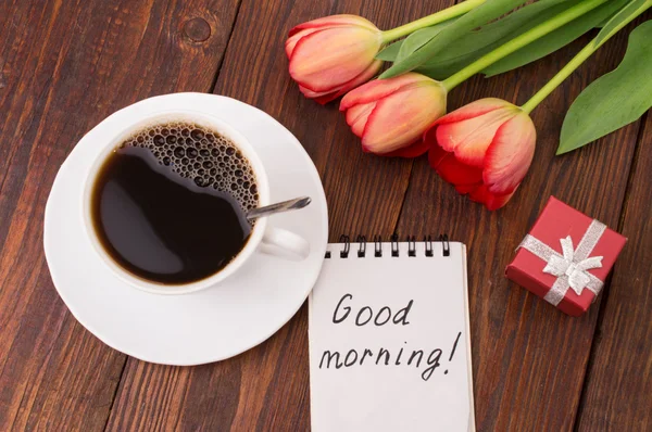 Cup of coffee, tulips, croissant, strawberries on wooden background ...