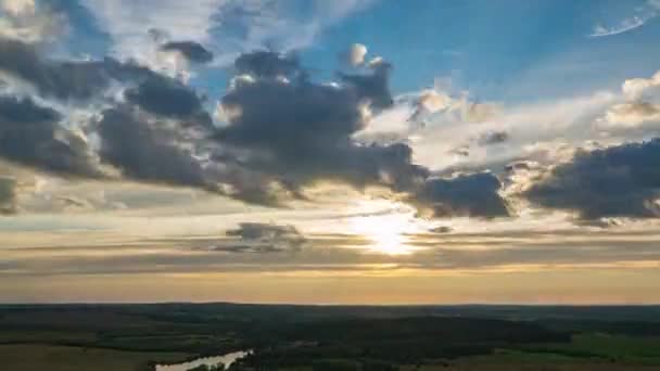 Schöne dramatische Zeitraffer des Sonnenuntergangs und der Wolken am blau-orangen Himmel. Die Sonne geht über dem Horizont auf dem Feld unter. — Stockvideo
