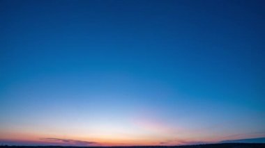 Yavaş sol kamera hareketi. Mavi gökyüzü ile doğal yeşil buğday tarlası ve güneşli bir günde bulutlar, gün doğumu. Doğal arka plan. Tarım arazisi, güzel renkli buğday, zaman aşımı, 4k hiperhız.