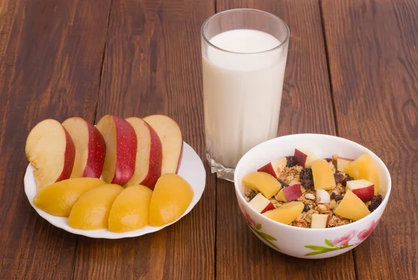muesli with peach, apple and a glass of milk