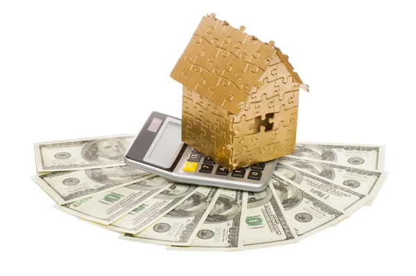 Huis van goud kleur op een rekenmachine en dollars — Stockfoto