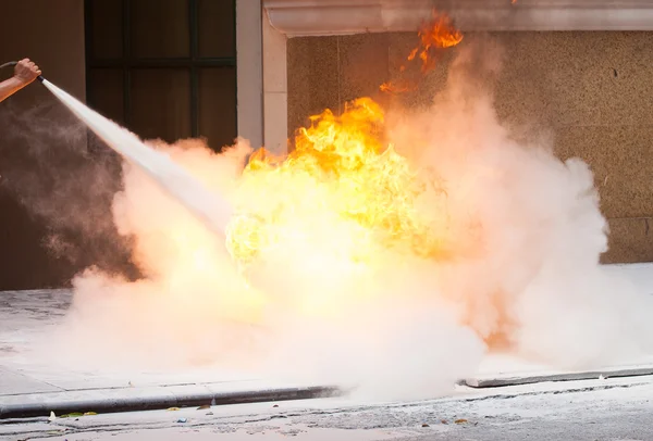 Mann bekämpft Brand mit Feuerlöscher lizenzfreie Stockbilder