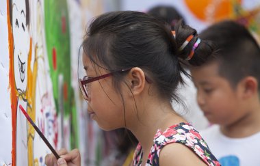 Görüntüleri çizim ve onların isteklerine boya fırça ile duvara yazı Asya çocuk