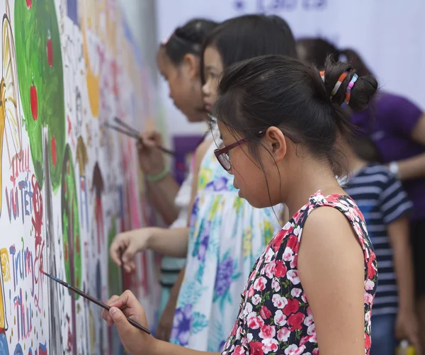 Asiatische Kinder malen Bilder und schreiben ihre Wünsche mit dem Pinsel an die Wand — Stockfoto