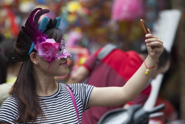 Vietnamlı kız renkli bir maske ile fotoğraf (selfie) çekiyor