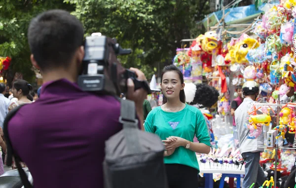 Camarógrafo asiático filmando a una periodista en el sitio — Foto de Stock