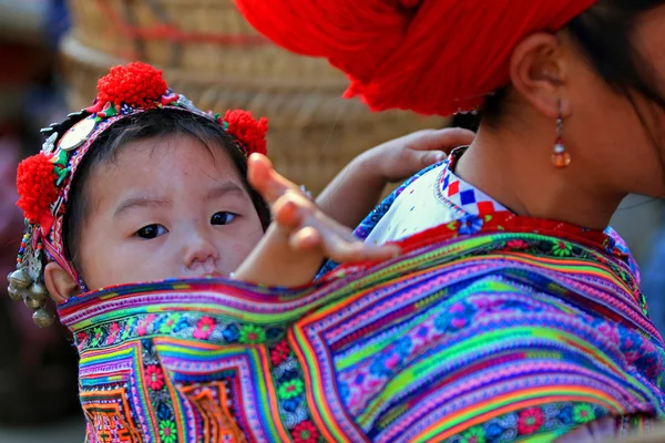 Hmong çocuk bir bit pazarına anne takip ederken elini sallayarak