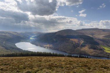 Brecon Beacons, İngiltere 'deki Talybont rezervuarının üzerinde güneş ışığı ve yağmur bulutları