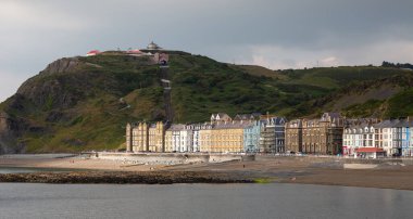 Editör Aberystwyth, İngiltere - 27 Haziran 2021: Aberystwyth 'deki Anayasa Tepesi' ndeki uçurum demiryolu füniküleri ve Galler 'in Aberystwyth kentindeki North Beach' teki renkli Victorian misafir evleri.