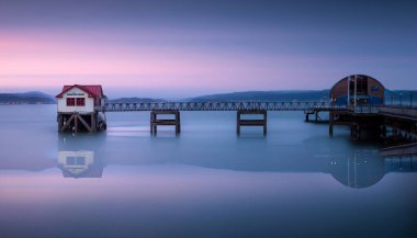 Swansea Körfezi, Güney Galler, İngiltere 'de inşa edilen yeni bir tekne yüzünden artık kullanılmayan Mumbles iskelesindeki eski cankurtaran evi..