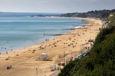 Bournemouth, İngiltere - 15 Eylül 2021: İngiltere 'de Bournemouth' un West Cliff Beach 'indeki sosyal mesafeyi gözlemleyen tatilciler