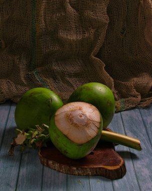 Ahşap masada yeşil hindistan cevizi suyu