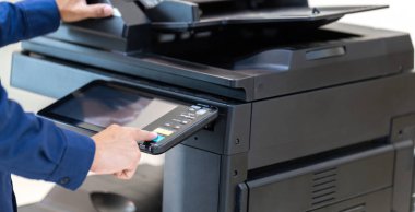 İşadamı, yazıcı fotokopi ağı panelindeki düğmeye basar, ofis konseptinde fotokopi üzerinde çalışır, yazıcı, kağıt tarama ve kopyalama için ofis çalışanı ekipmanıdır.