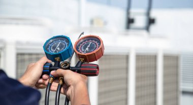 Teknisyen klimayı kontrol ediyor, klimaları, servis ve bakım klimalarını doldurmak için ölçüm aletleri kullanıyor. .