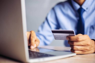 Çevrimiçi ödeme, adamın elleri kredi kartı tutuyor ve online alışveriş için akıllı telefon kullanıyor.