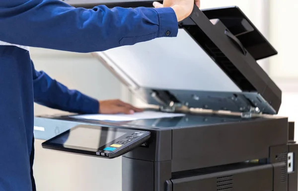 İşadamı, yazıcı fotokopi ağı panelindeki düğmeye basar, ofis konseptinde fotokopi üzerinde çalışır, yazıcı, kağıt tarama ve kopyalama için ofis çalışanı ekipmanıdır.