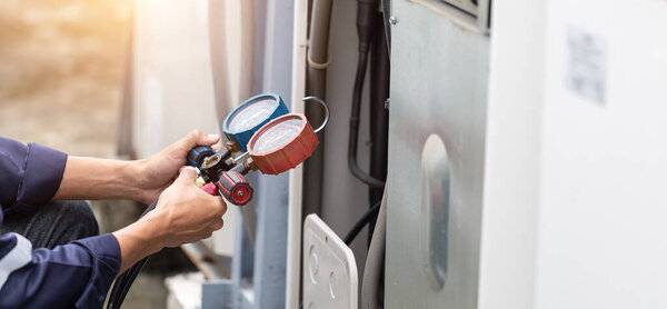 Technician is checking air conditioner ,measuring equipment for filling air conditioners.