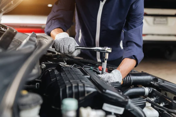 Automobile mechanic repairman hands repairing a car engine automotive workshop with a wrench, car service and maintenance,Repair service.