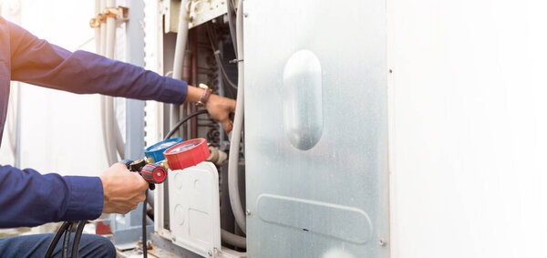 Technician is checking air conditioner ,measuring equipment for filling air conditioners.