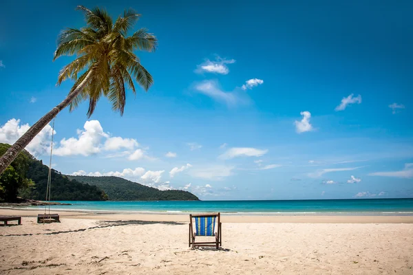 Кокосове дерево і пляжне дерев'яне ліжко на білому піску з красивим блакитним морем над прозорим блакитним небом — стокове фото