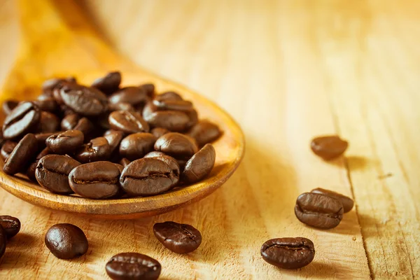 coffee beans on wooden spoon.