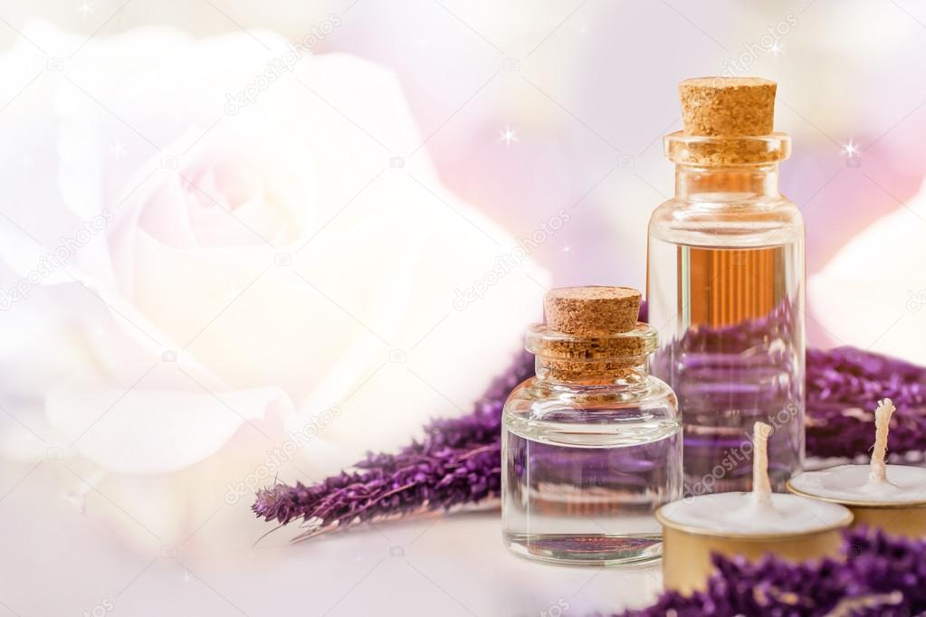 bottle of aroma essential oil with candle and flower