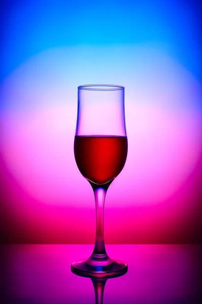 Bicchiere di vino rosso in sfondo sfumato magenta blu — Foto Stock