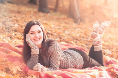 Bir sonbahar park bir halıya yatan genç kadın