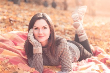 Bir sonbahar park bir halıya yatan genç güzel kadın