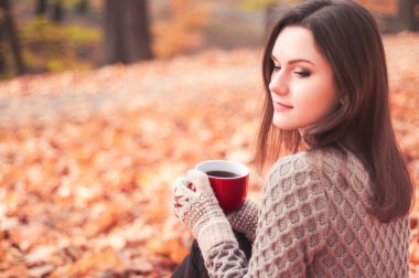 Bir parkta oturan ve çay içme genç kadın