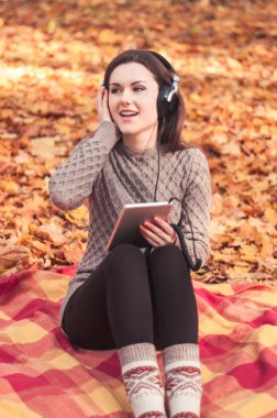 Bir halının üzerinde oturan ve müzik genç kadın