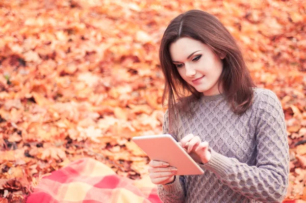 Genç kadın bir parkta tablet kullanma