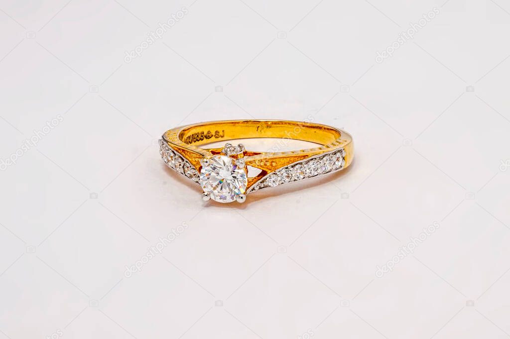 Golden diamond wedding ring on white background 