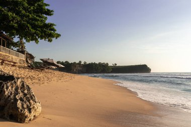 Bali Endonezya 'nın arka planında yeşil tepeler olan boş plaj