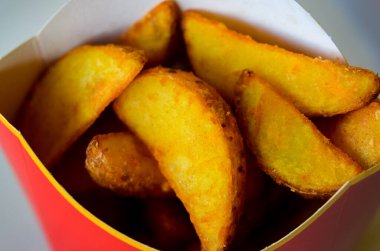 Bir kutunun içine tuz serpiştirilmiş kızarmış patates kamışı. Bir kafeden ya da fast food restoranından yemek almak. Yüksek kaliteli yatay yakın plan fotoğraf