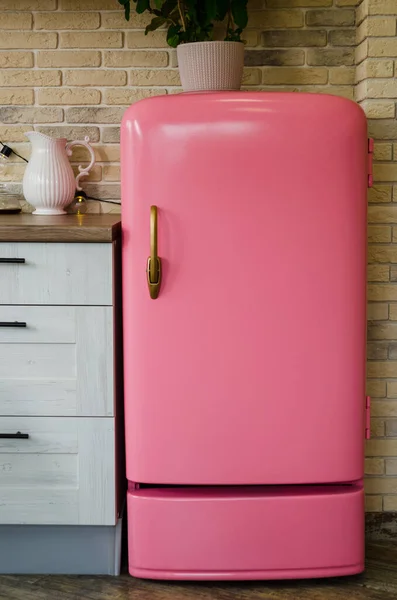 Retro style pink fridge in vintage kitchen in daylight