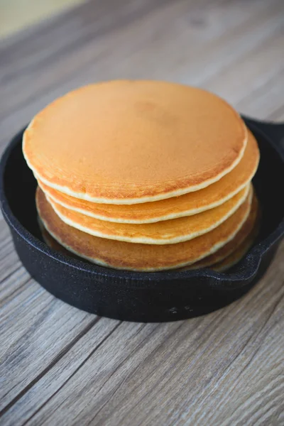 Stack of pancakes in frying pan with maple syrup — Stock Photo, Image