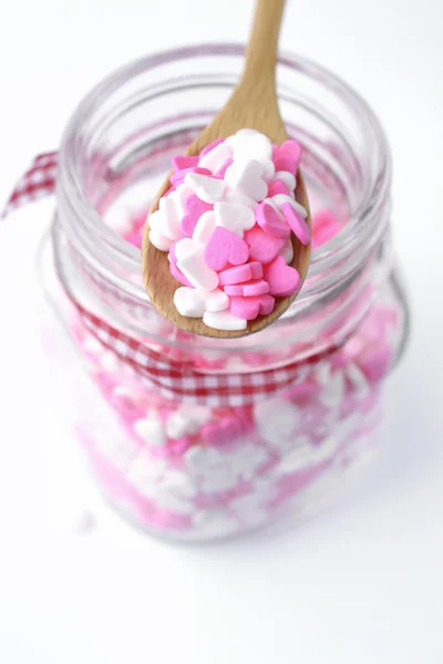 Corazón espolvorea rosa y blanco sobre la cuchara de madera, símbolo de amor — Foto de Stock