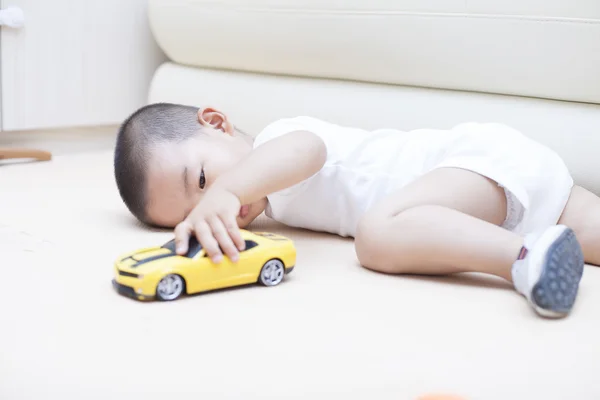 Schattige Chinese babyjongen spelen een speelgoedauto binnenshuis — Stockfoto