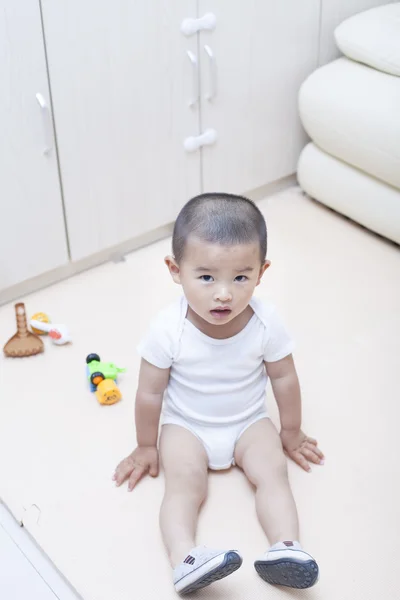 Cute Chinese baby boy playing a toy car indoors — Stock Photo, Image