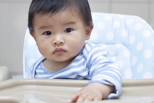 Cute Chinese baby boy sitting in baby chair — Stock Photo, Image