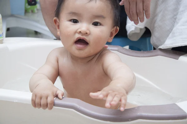 Chinese father washing baby in bathtub — Stock Photo, Image