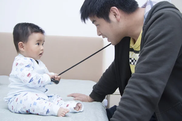 Chinesisch vater und sohn spielend im bett — Stockfoto